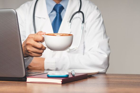 A doctor holding a coffee